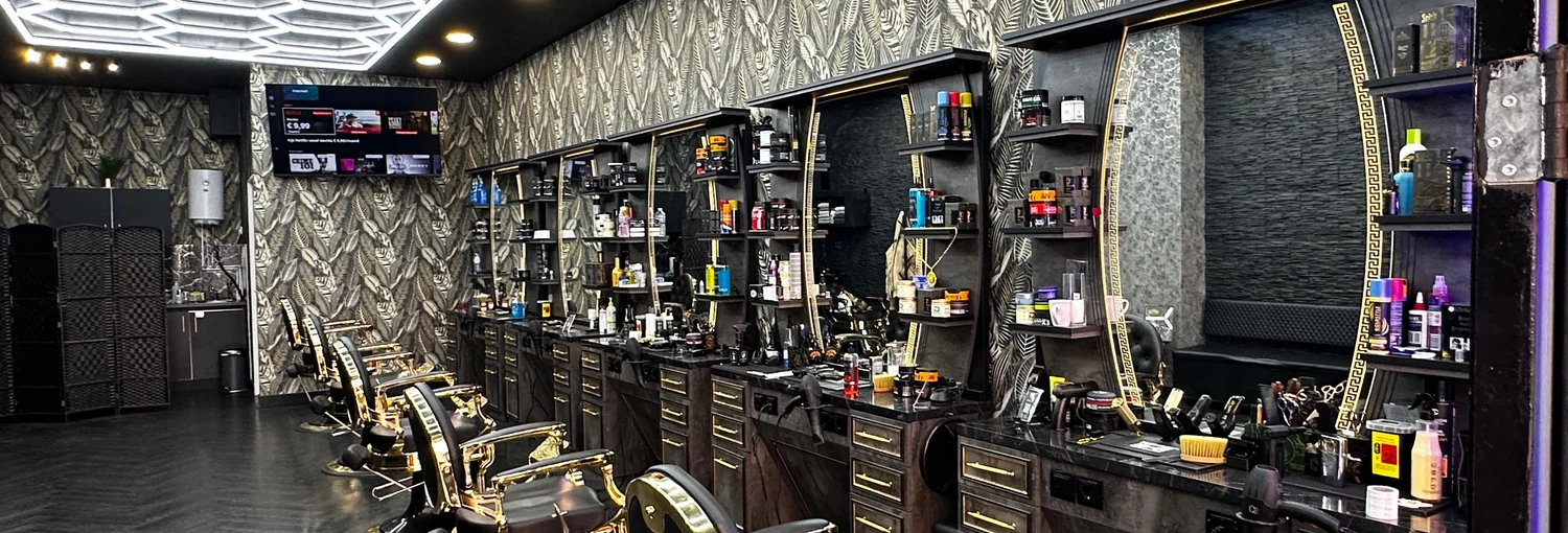 De salon met gouden barberstoelen en verlichte plafondpatronen